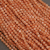 Close-up of pinkish-orange beads on a gray surface