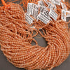Peach-colored beads with labels on a gray background