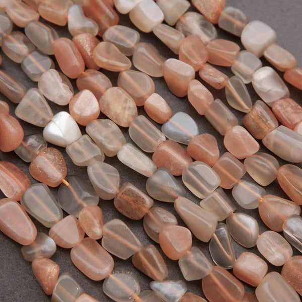 Close-up of pink and gray stone beads on a dark surface