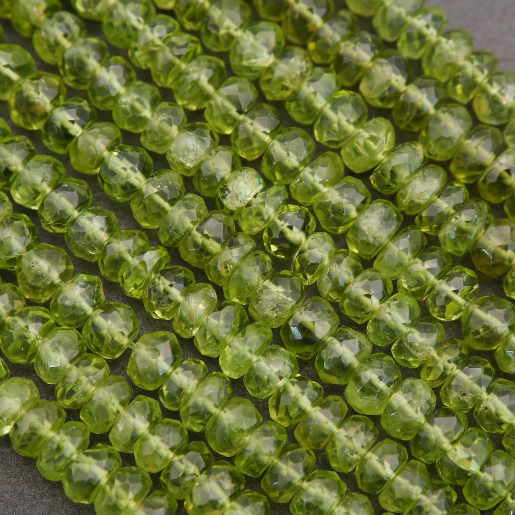 Close-up of green peridot beads on a gray background