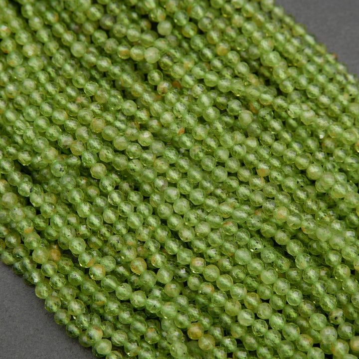 Green round faceted beads with yellow inclusions.