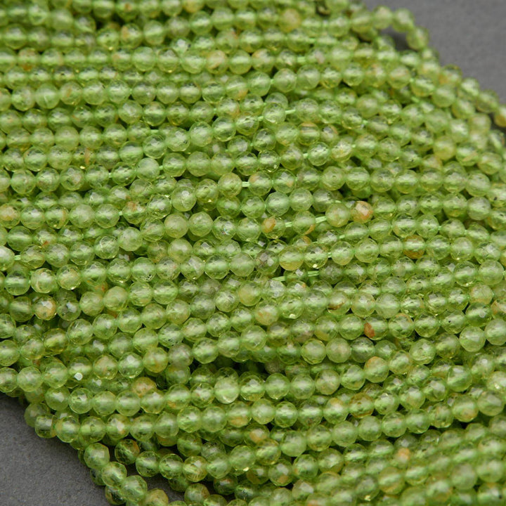 Green round faceted beads with yellow inclusions.