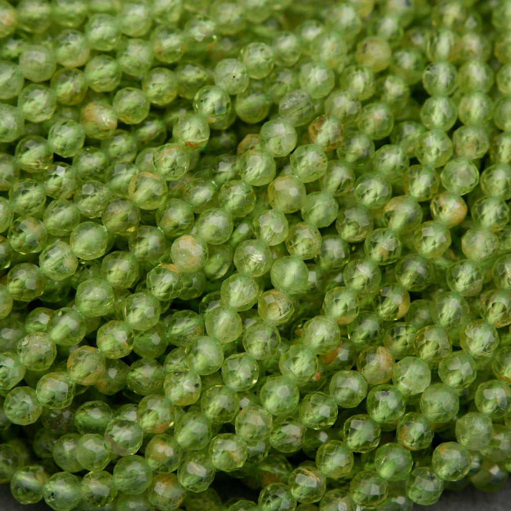Green round faceted beads with yellow inclusions.