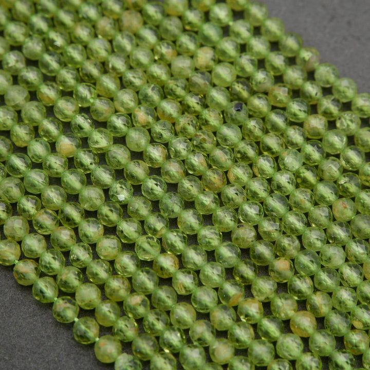 Green round faceted beads with yellow inclusions.