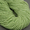 Close-up of a skein of green yarn on a dark background
