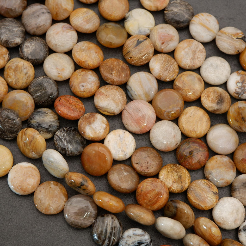 Close-up of mixed natural gemstone beads showing organic color variation in beige, tan, and brown hues.