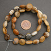 Natural stone round bead strand displayed with neutral tones and organic surface detail.