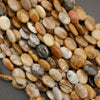 Detailed view of polished oval stone beads with organic banding and earthy neutral tones.
