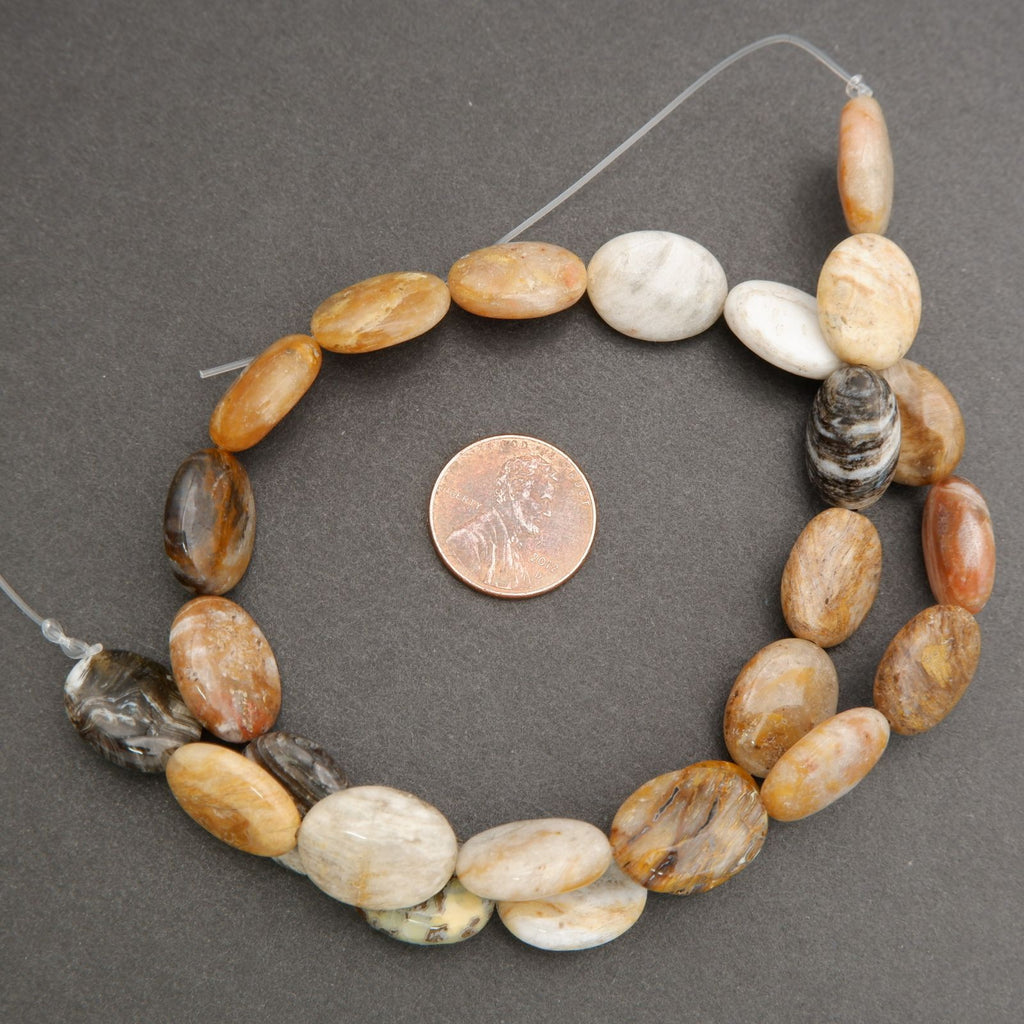 Macro image of polished oval beads highlighting natural patterns, textures, and glossy finish.