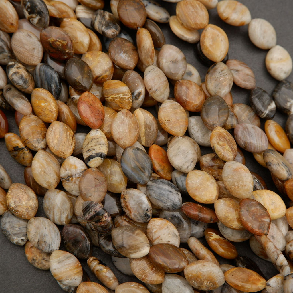 Close-up of marquise-shaped gemstone beads showing natural banding in beige, tan, and brown hues.