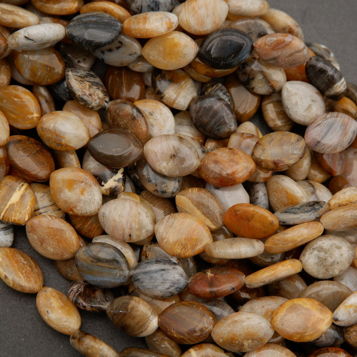 Detailed view of polished marquise oval beads with organic patterns and earthy neutral colors.
