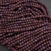 Close-up of a string of purple beads on a gray background