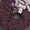 Purple beads with labels on a gray background