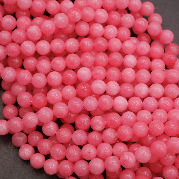 Strands of pink jade round beads with natural color variation