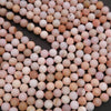 Close-up of pink and white marbled beads on a black background