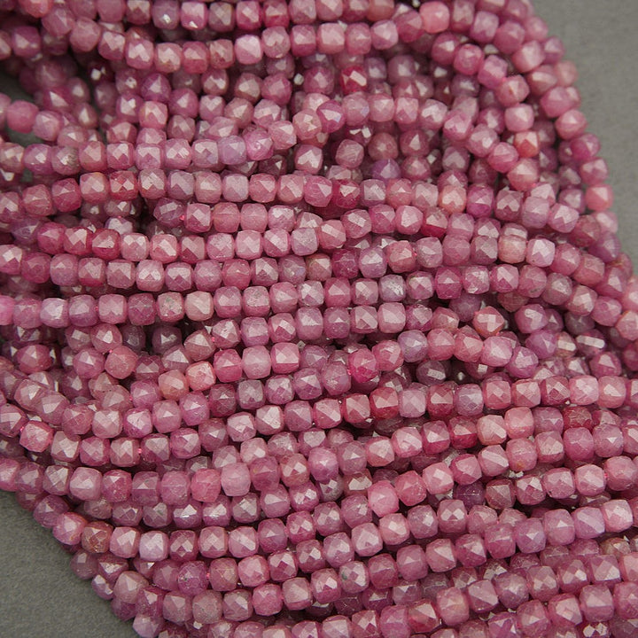Close-up of faceted ruby beads showing translucent pink-red hues