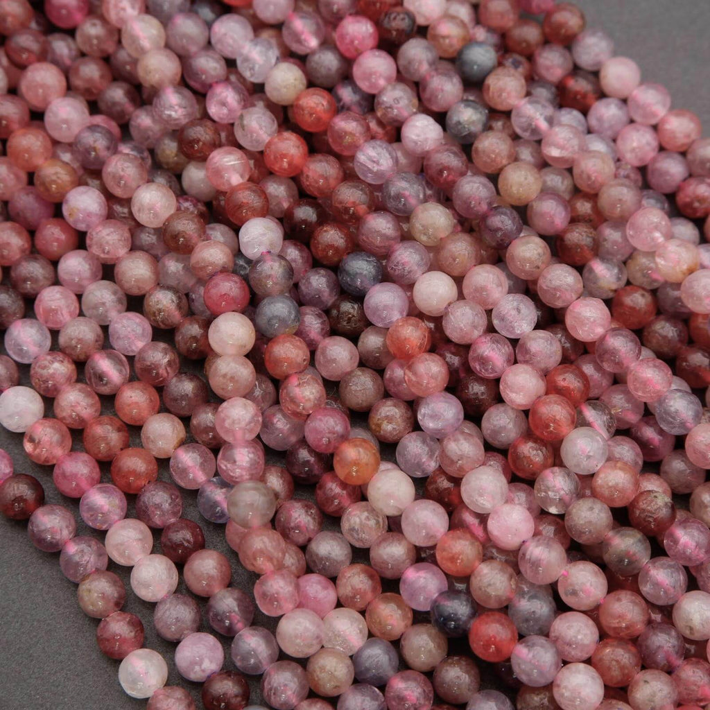 Close-up of pink and red marbled beads on a gray background