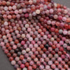Close-up of pink and red marbled beads on a gray surface