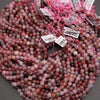Stack of multicolored beads with price tags on a gray surface