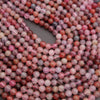 Close-up of pink and red marbled beads on a dark background
