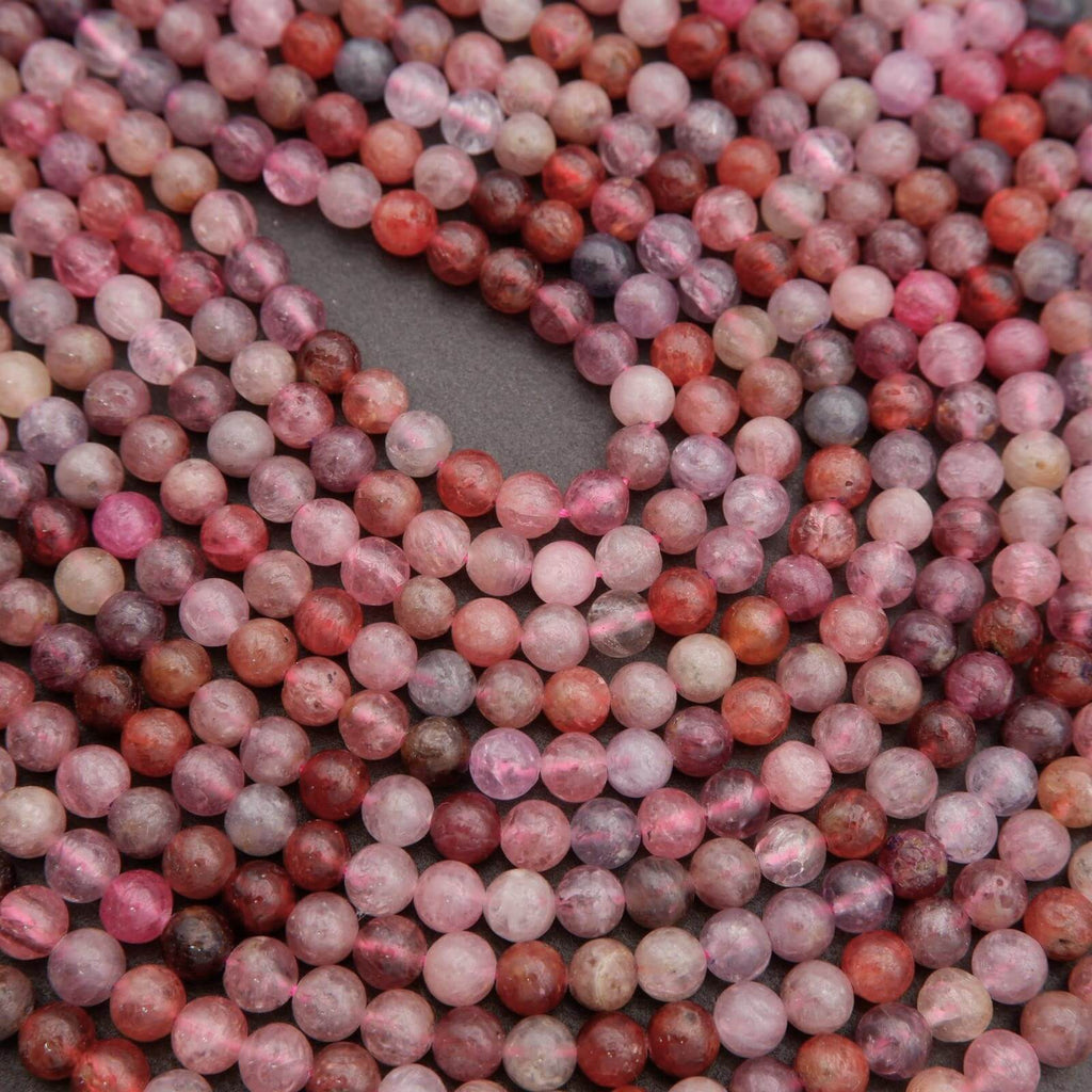 Close-up of pink and red marbled beads on a dark background