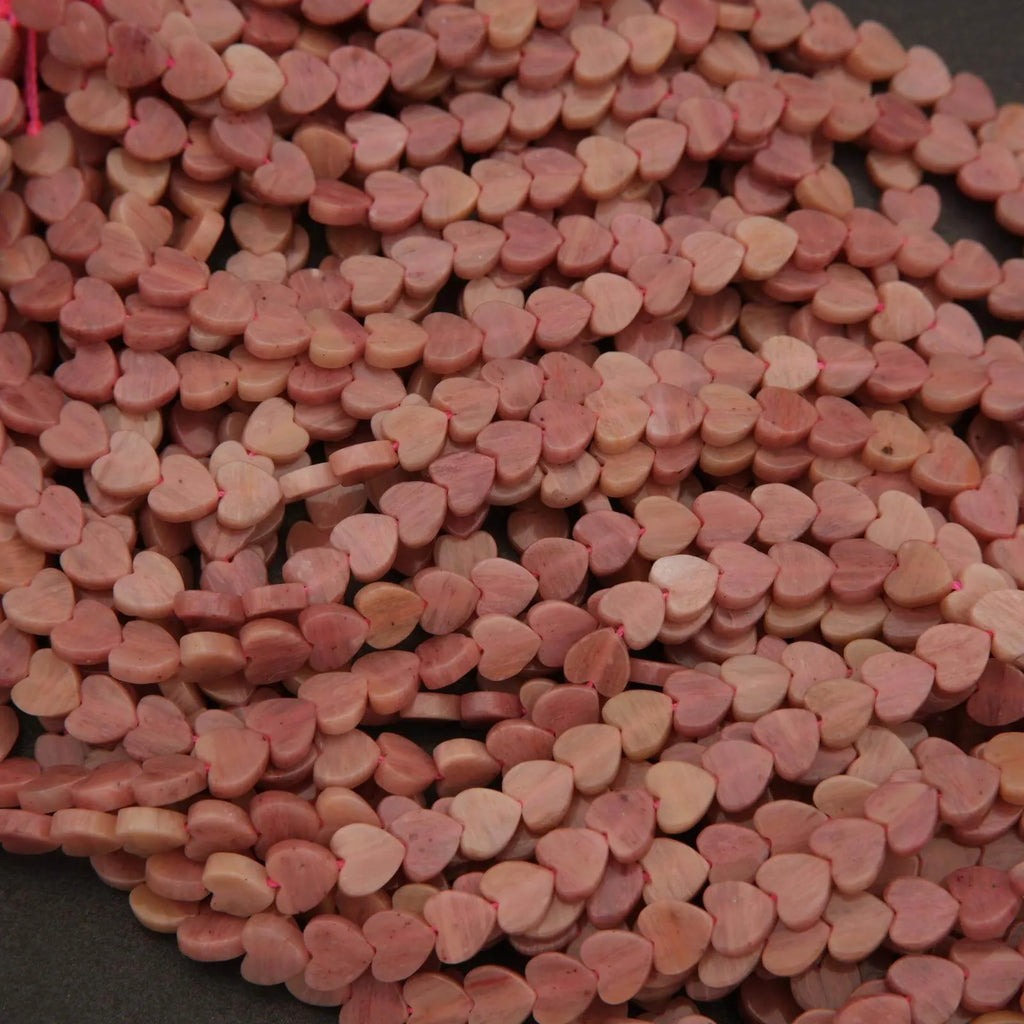 Close-up of a pile of pink heart-shaped objects on a dark surface
