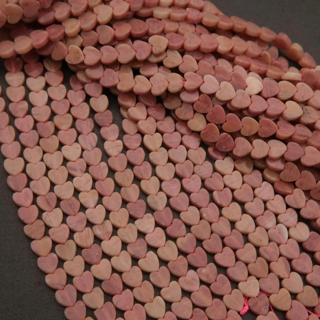 String of pink heart-shaped beads on a dark background