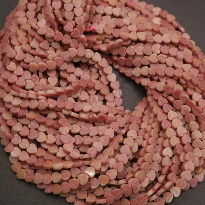 String of pink heart-shaped beads on a dark background
