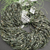 String of green prehnite beads with labels on a gray surface