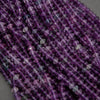Close-up of a string of purple beads on a gray background