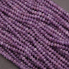 Close-up of a string of purple beads on a gray background