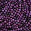 Close-up of purple beads with a dark background