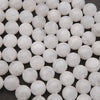 Close-up of white spherical beads on a dark background