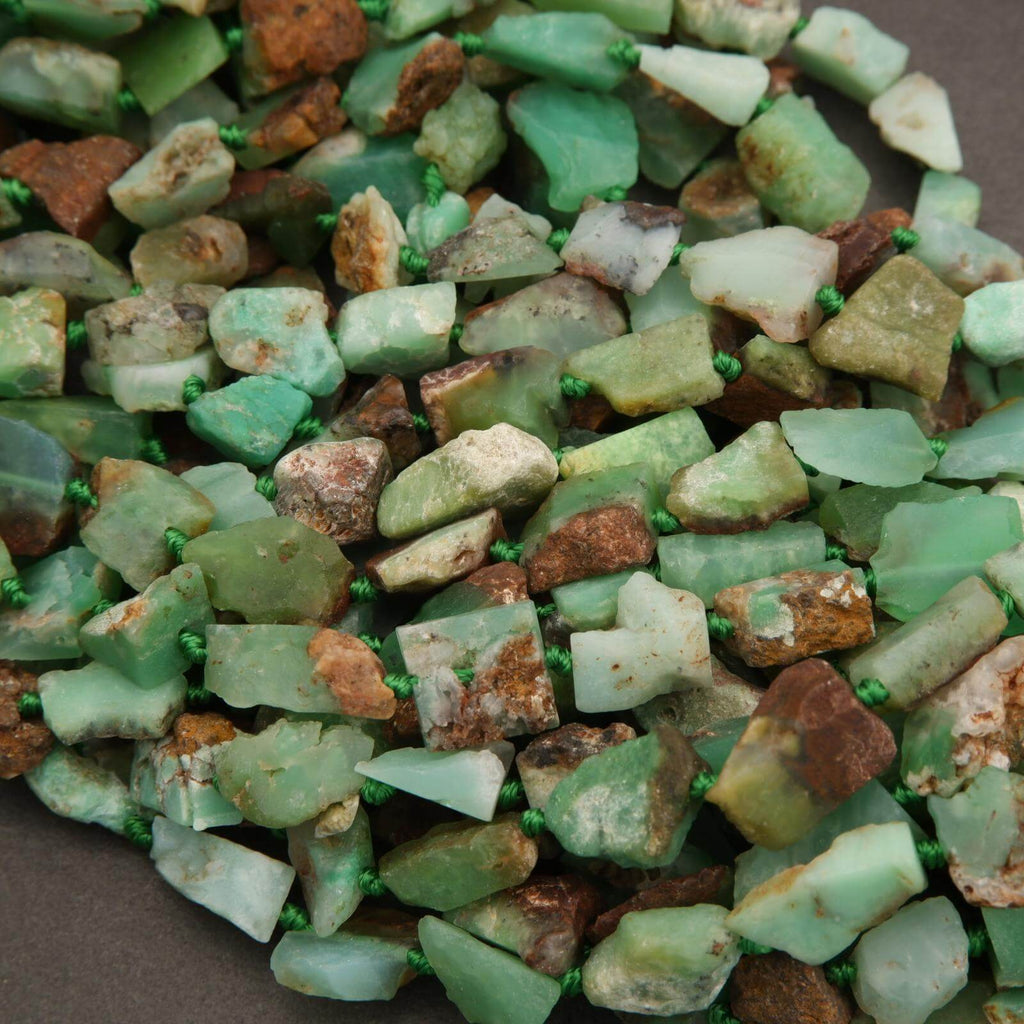 Assorted green and brown stones on a dark surface
