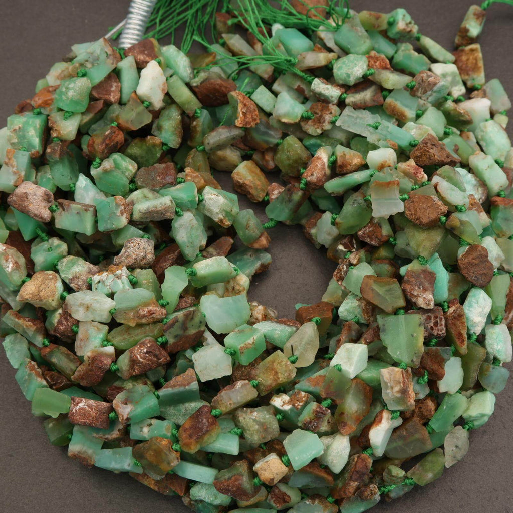 Decorative wreath made of green and brown stones on a plain background