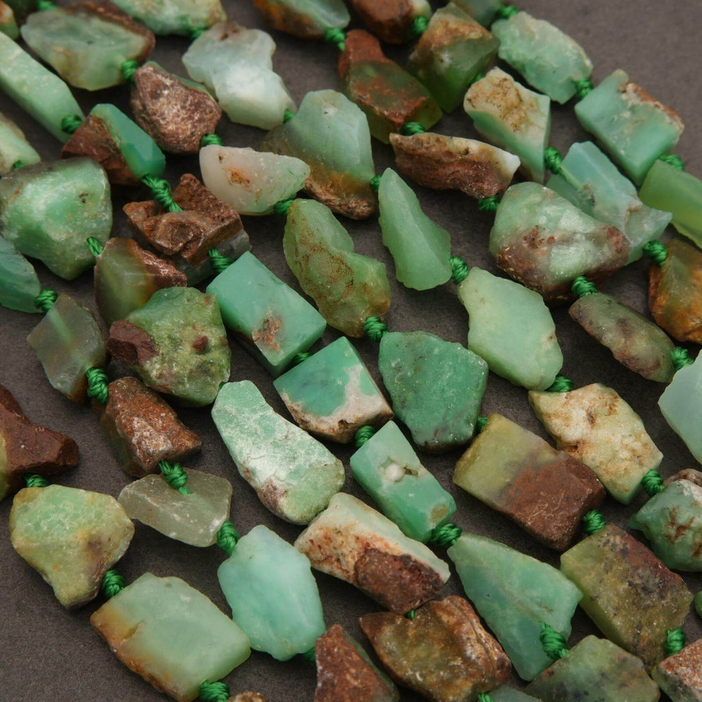 Close-up of green and brown stone beads on a dark surface