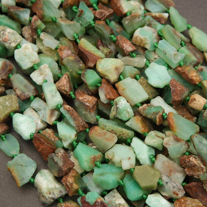 Close-up of green and brown stones with small beads on a brown background