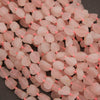 Close-up of pink stone beads on a dark background