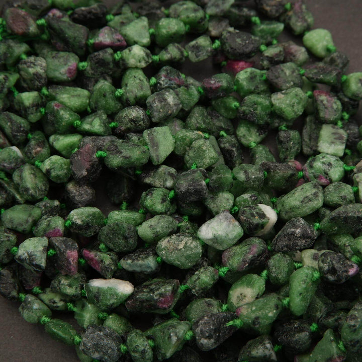 Close-up of green and purple gemstones on a dark background