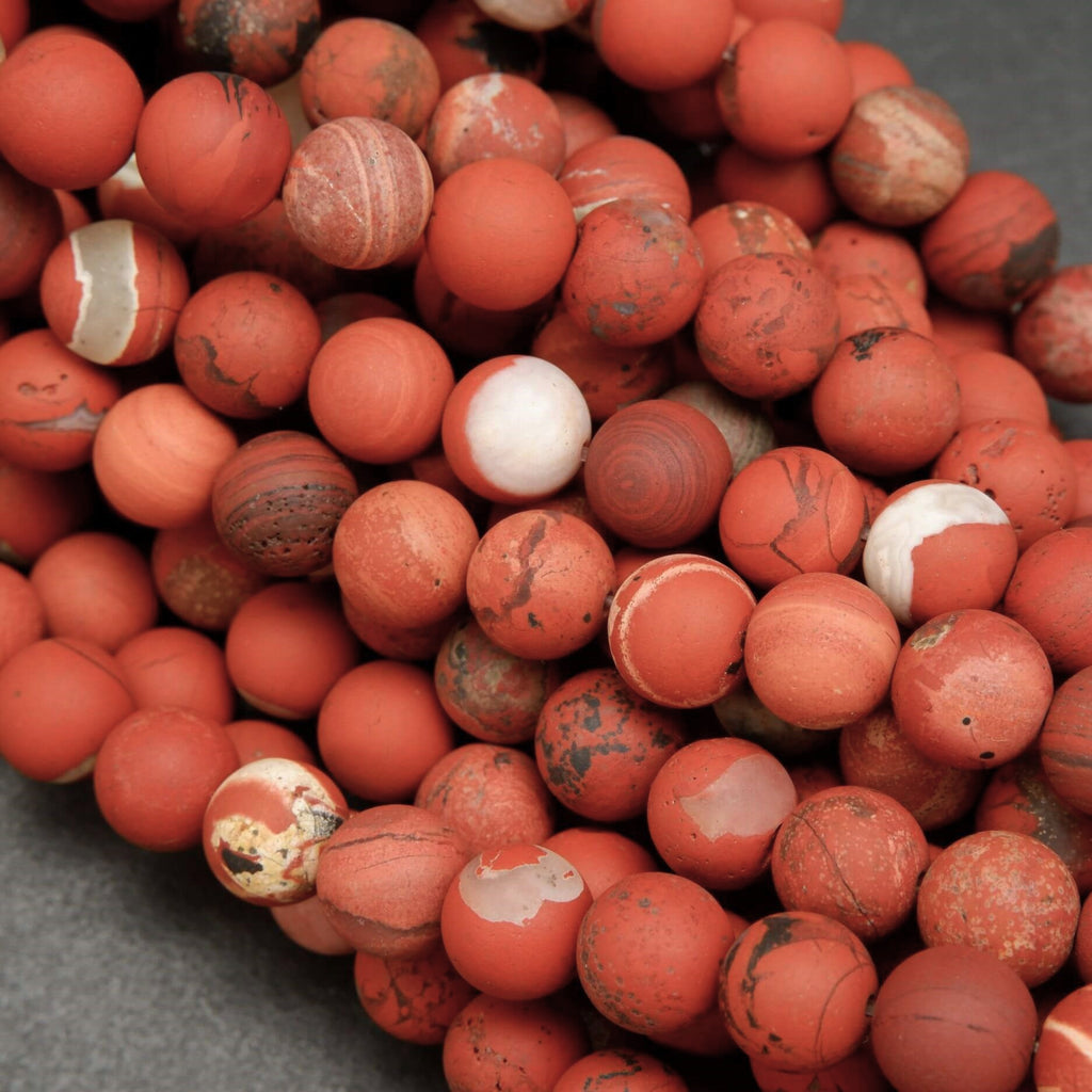 Close-up of red marbled beads on a gray surface