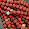 Close-up of a pile of red and white marbled balls on a gray background