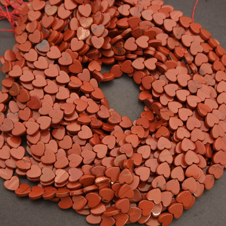 String of red heart-shaped beads on a dark surface