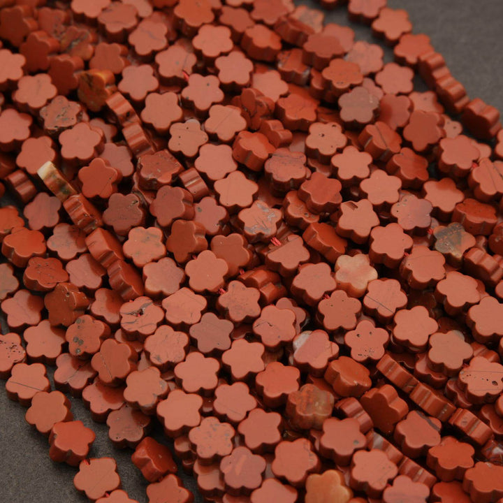 Close-up of red flower-shaped beads on a dark surface