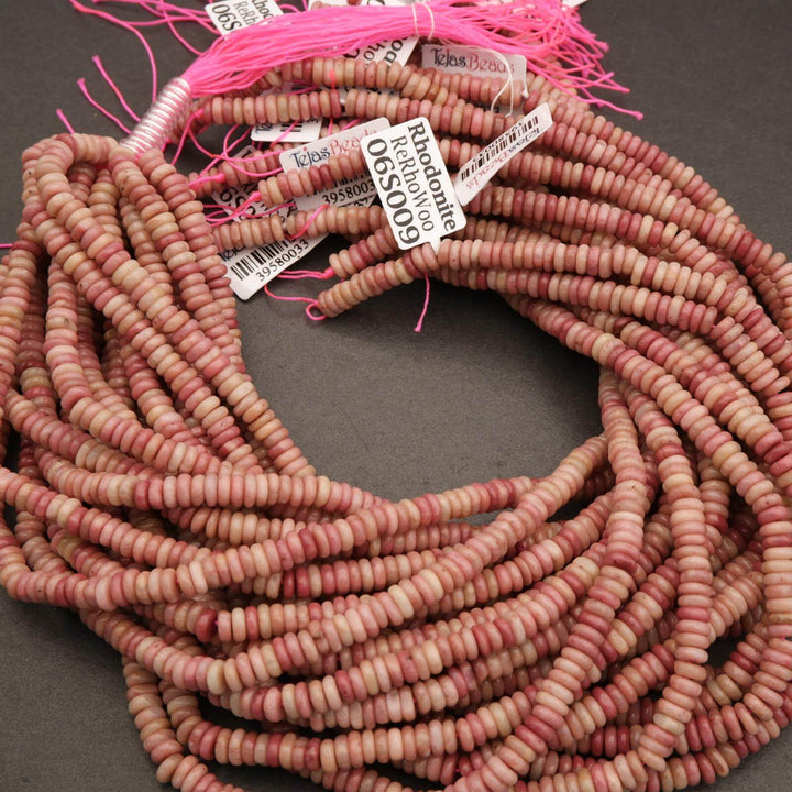 Beads with pink tassels and labels on a dark background