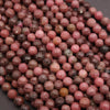 Close-up of pink and brown faceted beads on a dark background