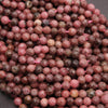 Close-up of faceted pink and brown beads on a dark background