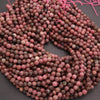 String of pink and brown beads on a dark surface