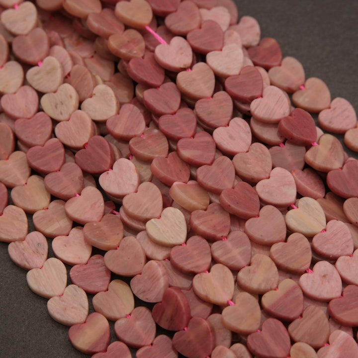 Close-up of pink heart-shaped beads on a dark surface