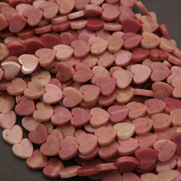 Close-up of pink heart-shaped beads on a dark surface