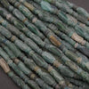 Close-up of green and brown stone beads on a dark background